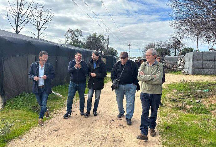 Francisco Sierra junto a dirigentes de IU Huelva y otras personas durante una visita al asentamiento de personas migrantes en la localidad de Lucena del Puerto (Huelva)