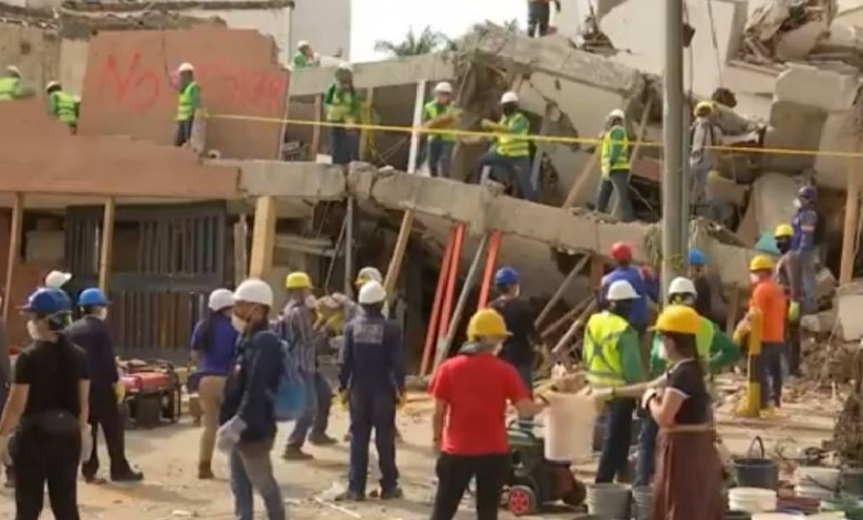 Grupos de personas en labores de rescate en los restos de un edificio destruido por el terremoto en Colombia.