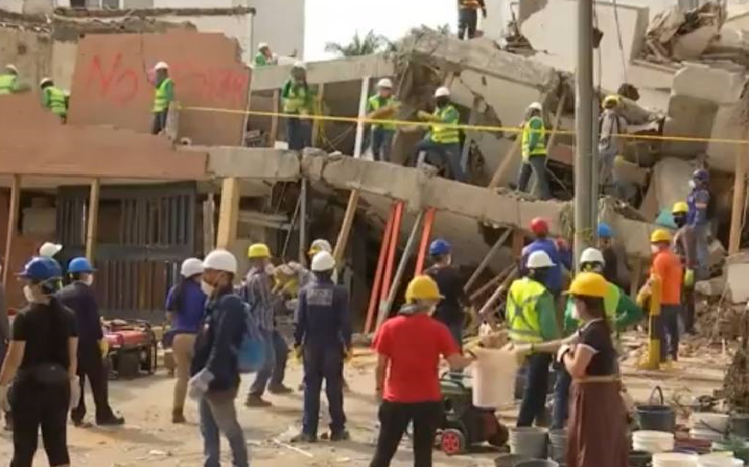 Grupos de personas en labores de rescate en los restos de un edificio destruido por el terremoto en Colombia.